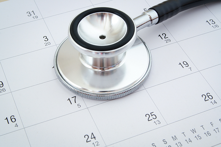 Quanto tempo dura uma faculdade de enfermagem:  parte de um estetoscópio em cima de uma calendário